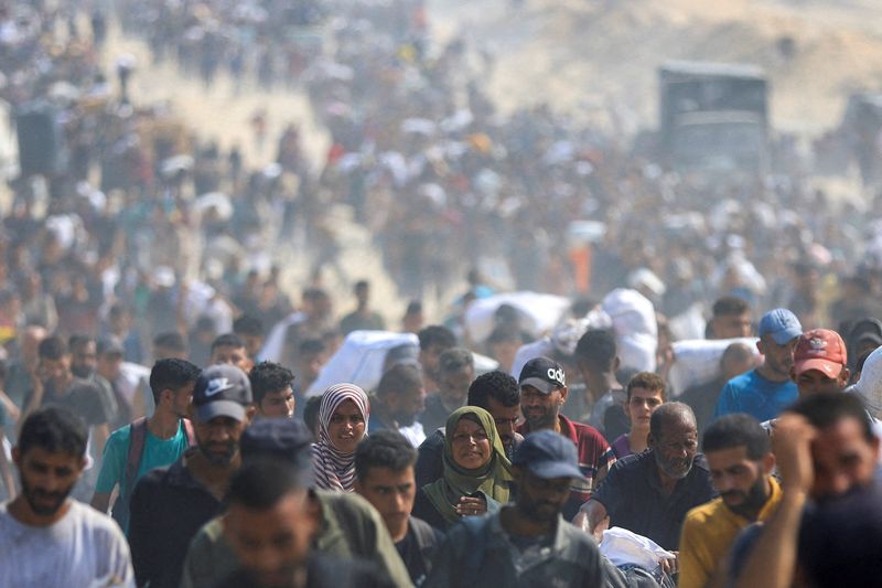 FILE PHOTO: Palestinians carry aid supplies they collected from trucks that entered Gaza through Israel, in Beit Lahia, in the northern Gaza Strip August 10, 2025. REUTERS/Dawoud Abu Alkas/File Photo