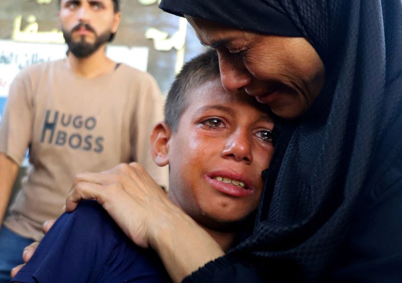 Mourners react during the funeral of Palestinians killed in Israeli fire while seeking aid on Wednesday, according to medics, in Gaza City, August 14, 2025. REUTERS/Ebrahim Hajjaj      TPX IMAGES OF THE DAY