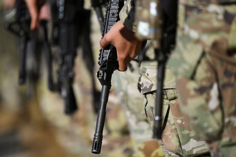 FILE PHOTO: U.S. troops in transfer to military base in Grafenwoehr to strengten NATO efforts in Eastern Europe as Russian invasion on Ukraine continues, carrying rifles stand in formation at the Albrecht Duerer Airport in Nuremberg, Germany March 1, 2022. REUTERS/Andreas Gebert/File Photo