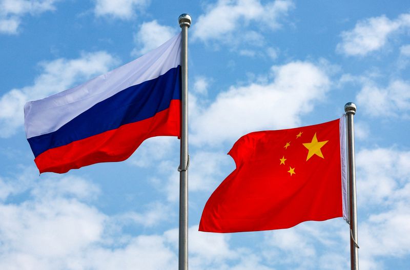 FILE PHOTO: Chinese and Russian flags fly at an airport before a ceremony to welcome Russian President Vladimir Putin, who arrives to attend the Shanghai Cooperation Organisation (SCO) summit in Tianjin, China August 31, 2025. Sputnik/Vladimir Smirnov/Pool via REUTERS/File photo