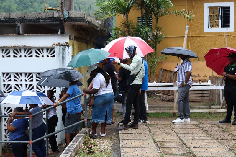 People stand in line at a polling station to cast their votes in the general election, in Kingston, Jamaica September 3, 2025. REUTERS/Gilbert Bellamy