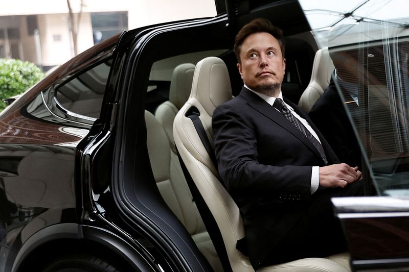 FILE PHOTO: Tesla Chief Executive Officer Elon Musk gets in a Tesla car as he leaves a hotel in Beijing, China May 31, 2023. REUTERS/Tingshu Wang/File Photo