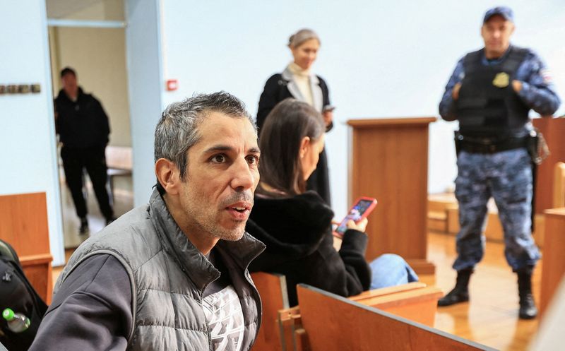 French cyclist Sofiane Sehili, who was found guilty of illegally crossing the Russian border while attempting to break the world record for the fastest cycle crossing of the Eurasian landmass and freed by a court that ordered him to pay a fine, sits in a courtroom in the far eastern settlement of Pogranichniy, Russia, October 23, 2025. REUTERS/Tatiana Meel