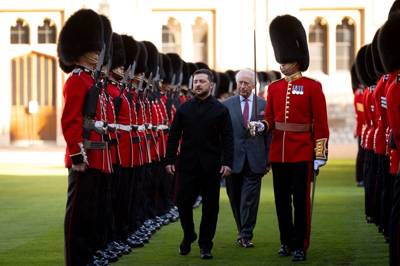 Britain's King Charles, Ukrainian President Volodymyr Zelenskiy and Major Ben Tracey inspect a guard of honour at Windsor Castle, Berkshire, Britain, October 24, 2025.    Aaron Chown/Pool via REUTERS