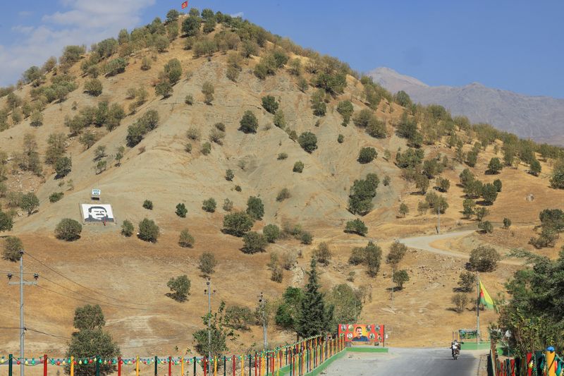 A portrait of jailed Kurdistan Workers Party (PKK) leader Abdullah Ocalan and a sign with the words "Serok Apo," are displayed on a hillside in the Qandil mountains, Iraq, October 26, 2025. REUTERS/Thaier Al-Sudani