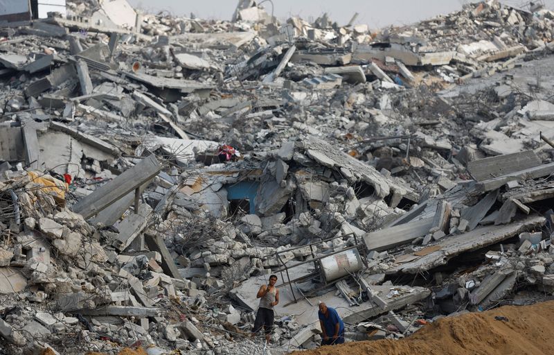 Palestinians work amid the rubble of destroyed buildings, during a ceasefire between Israel and Hamas, in Jabalia, northern Gaza Strip, November 4, 2025. REUTERS/Mahmoud Issa