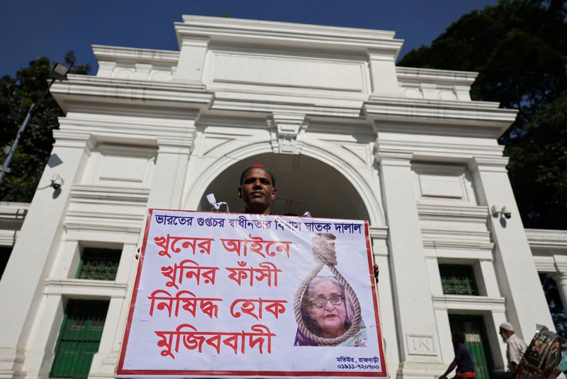 A man holds a poster in front of the court demanding the capital punishment ahead of the verdict on charges of crimes against humanity for a deadly crackdown on student-led protests in 2024 against the ousted Prime Minister Sheikh Hasina, in Dhaka, Bangladesh, November 17, 2025. REUTERS/Mohammad Ponir Hossain