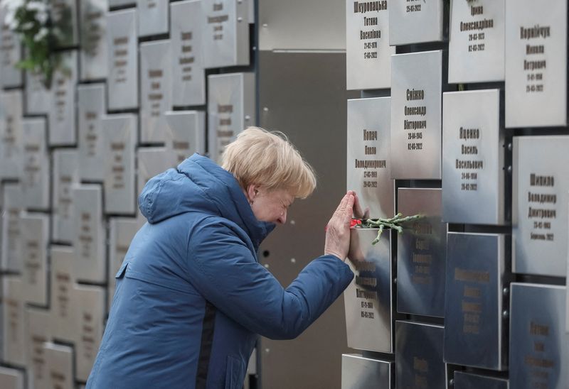 FILE PHOTO: A woman visits the memorial to the victims of the Russian occupation, marking the third anniversary of the liberation of the town of Bucha during Russia's attack on Ukraine, in Bucha, near Kyiv, Ukraine, March 30, 2025. REUTERS/Gleb Garanich/File Photo