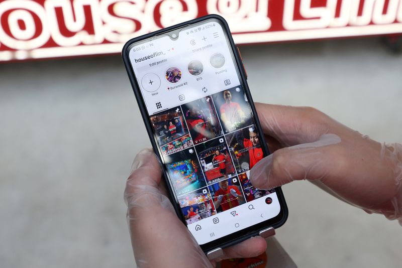 Dimi Heryxlim, 15, a social media content creator, poses while displaying his ‘House of Lim’ Instagram page at Burwood Chinatown in Sydney, Australia, November 14, 2025. REUTERS/Hollie Adams