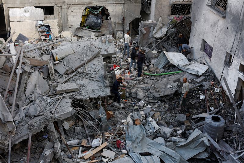 Palestinians inspect the site of Saturday's Israeli strike in the Central Gaza Strip, November 23, 2025. REUTERS/Mahmoud Issa