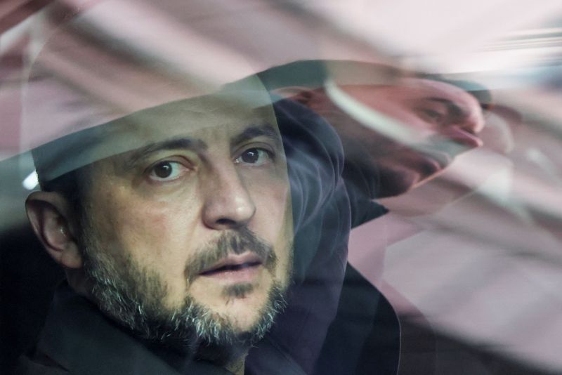 A security member is reflected on the window as Ukraine's President Volodymyr Zelenskiy sits inside a vehicle, after a visit at Spain's Parliament, in Madrid, Spain, November 18, 2025. REUTERS/Susana Vera