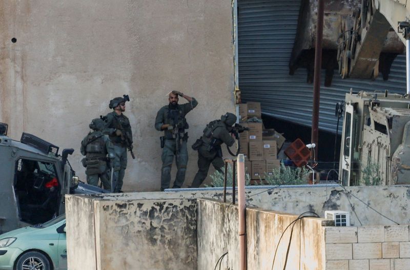 Israeli soldiers take position during a raid in Jenin in the Israeli-occupied West Bank, November 27, 2025. REUTERS/Mohamad Torokman
