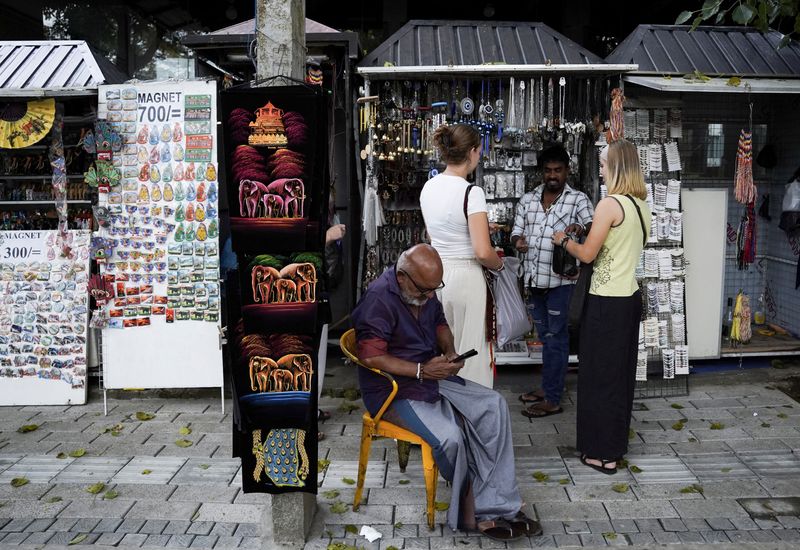 Tourists buy souvenirs from a roadside stall near the Temple of the Tooth, also known as Sri Dalada Maligawa, following Cyclone Ditwah, in Kandy, Sri Lanka, December 4, 2025. REUTERS/Akila Jayawardena