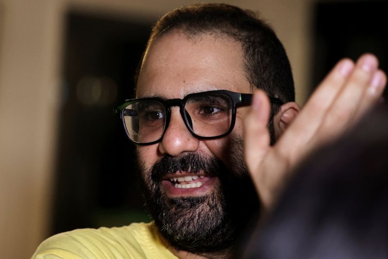 Prominent British-Egyptian activist Alaa Abd el-Fattah, who was released from prison after Egyptian President Abdel Fattah al-Sisi issued a presidential pardon for him, gestures as family and friends gather at home in Giza, Egypt, September 23, 2025. REUTERS/Mohamed Abd El Ghany