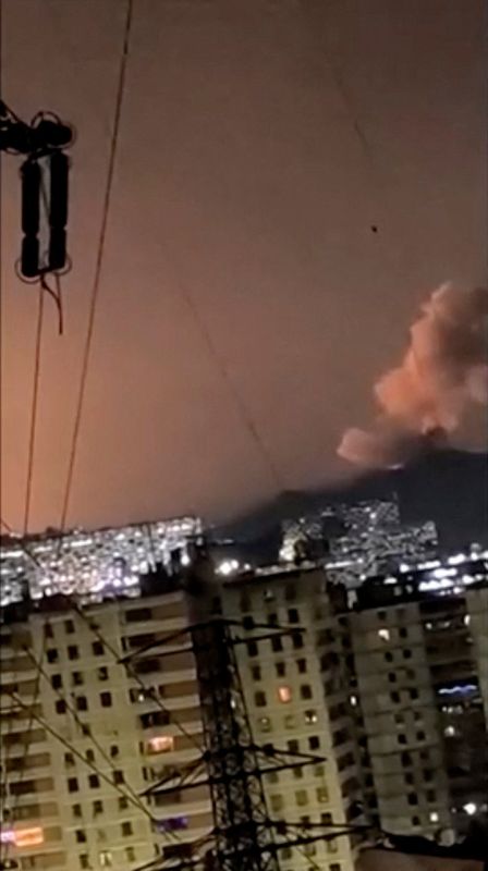 A column of smoke rises following an explosion, as the sky is illuminated by another explosion in the distance in the early hours of the morning, in Caracas, Venezuela, January 3, 2026 in this screen grab obtained from video obtained by Reuters. Video Obtained by Reuters/via REUTERS