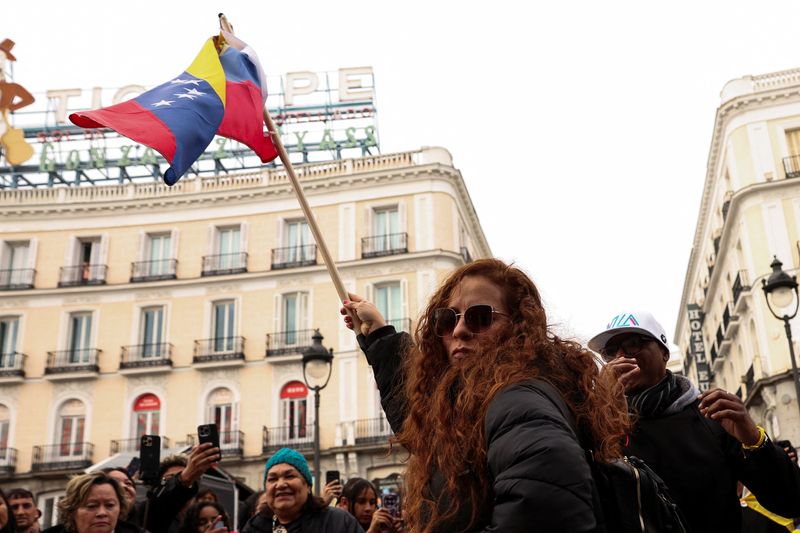 A woman waves a Venezuelan flag, as people react to the news after U.S. President Donald Trump said the U.S. has struck Venezuela and captured its President Nicolas Maduro, in Madrid, Spain, January 3, 2026. REUTERS/Violeta Santos Moura