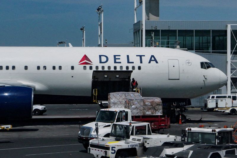 FILE PHOTO: Staff uploads packages on a Delta Air Lines plane at John F. Kennedy International Airport in Queens, New York City, U.S., April 23, 2025. REUTERS/Jeenah Moon//File Photo