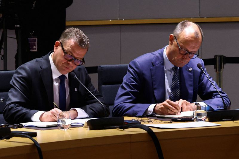 Finnish Prime Minister Petteri Orpo and German Chancellor Friedrich Merz sit at the roundtable on the day of a special summit of European Union leaders to discuss transatlantic relations following U.S. President Donald Trump's threats to impose new tariffs on goods from a list of EU countries over his demand to acquire Greenland, in Brussels, Belgium January 22, 2026. REUTERS/Yves Herman