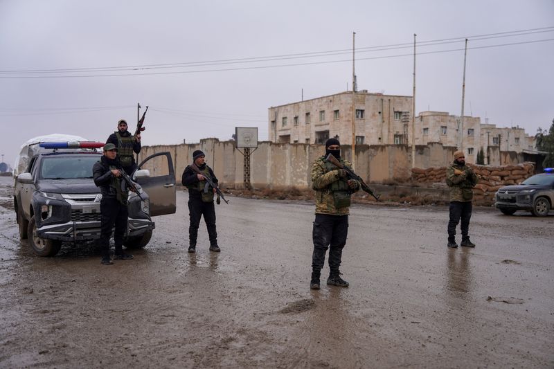 Members of the Syrian security forces stand guard outside al-Aqtan prison, where some Islamic State detainees are held, in Raqqa, Syria January 23, 2026. REUTERS/Karam al-Masri