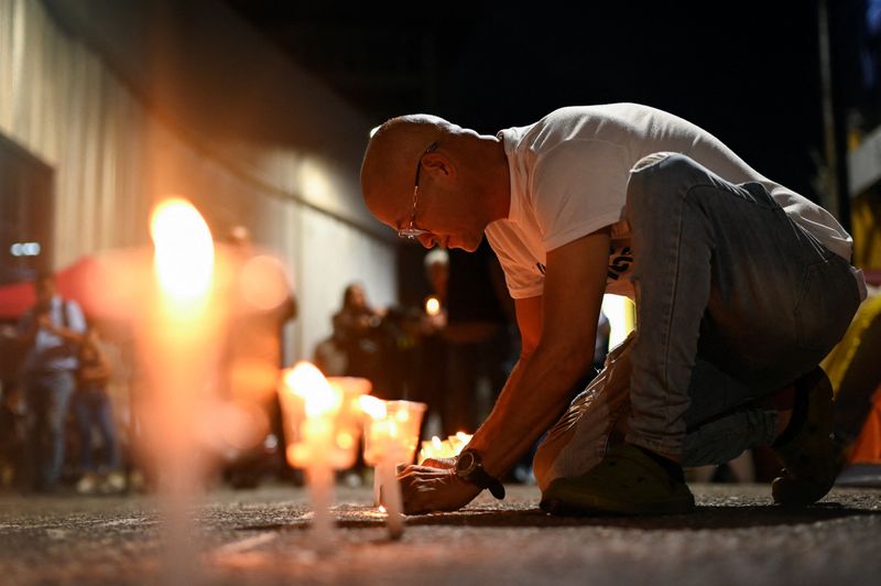 A relative of a prisoner lights a candle during a protest calling for the release of political prisoners, amid prisoner releases by the Venezuelan government following the U.S. capture of Nicolas Maduro, outside the National Police Zone 7 Detention Centre, in Caracas, Venezuela, January 23, 2026. REUTERS/Maxwell Briceno