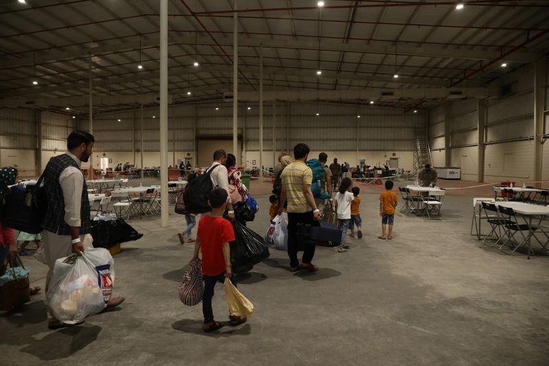 Special Immigrants from Afghanistan walk through the in-processing building after their evacuation at Camp As Sayliyah, Qatar, August 20, 2021. Picture taken August 20, 2021.  U.S. Army/Sgt. Jimmie Baker/Handout via REUTERS