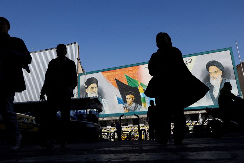 FILE PHOTO: People walk near a mural featuring images of Iran's Supreme Leader Ayatollah Ali Khamenei and leader of Iran's 1979 Islamic Revolution Ayatollah Ruhollah Khomeini, on a street in Tehran, Iran, February 17, 2026. Majid Asgaripour/WANA (West Asia News Agency) via REUTERS ATTENTION EDITORS - THIS PICTURE WAS PROVIDED BY A THIRD PARTY/File Photo