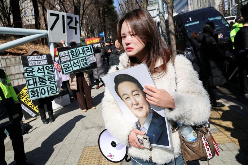 A woman reacts as a bus carrying former South Korean President Yoon Suk Yeol arrives at the Seoul Central District Court, for his sentencing trial in his insurrection case, stemming from his short-lived declaration of martial law in December 2024, in Seoul, South Korea, February 19, 2026. REUTERS/Kim Hong-ji