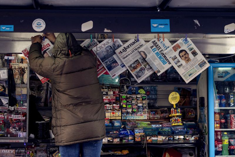 A newspaper seller arranges newspapers reporting the wave of violence in Mexico, following the killing of drug lord Nemesio Oseguera, known as 'El Mencho', in a military operation on Sunday, in Mexico City, Mexico, February 23, 2026. REUTERS/Quetzalli Nicte-Ha