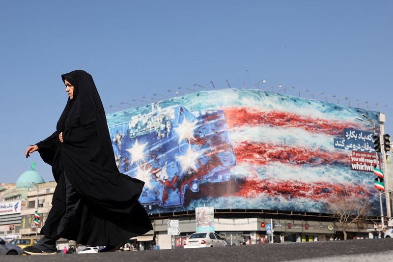 An Iranian woman walks past an anti-U.S. billboard in Tehran, Iran, February 26, 2026. Majid Asgaripour/WANA (West Asia News Agency) via REUTERS