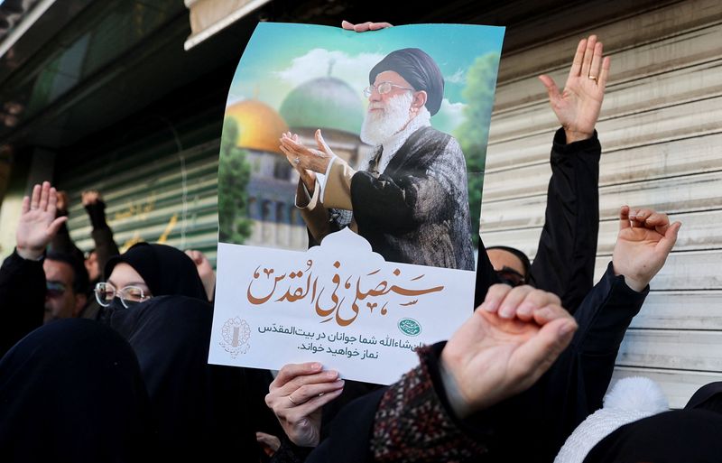 A woman holds a poster with the picture of Iran's Supreme Leader Ayatollah Ali Khamenei as people gather after Khamenei was killed in Israeli and U.S. strikes on Saturday, in Tehran, Iran, March 1, 2026. Majid Asgaripour/WANA (West Asia News Agency) via REUTERS