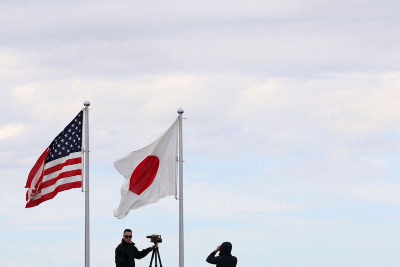Security personnel keep watch beneath the U.S. and Japan flags as U.S. President Donald Trump departs Haneda Airport for South Korea, in Tokyo, Japan, October 29, 2025. REUTERS/Evelyn Hockstein