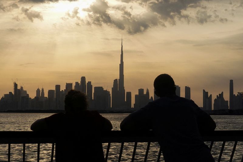 People way the sunset over Dubai, with a general view of the Dubai skyline, including Burj Khalifa, center, amid the U.S.-Israel conflict with Iran, in United Arab Emirates, March 6, 2026. REUTERS/Amr Alfiky