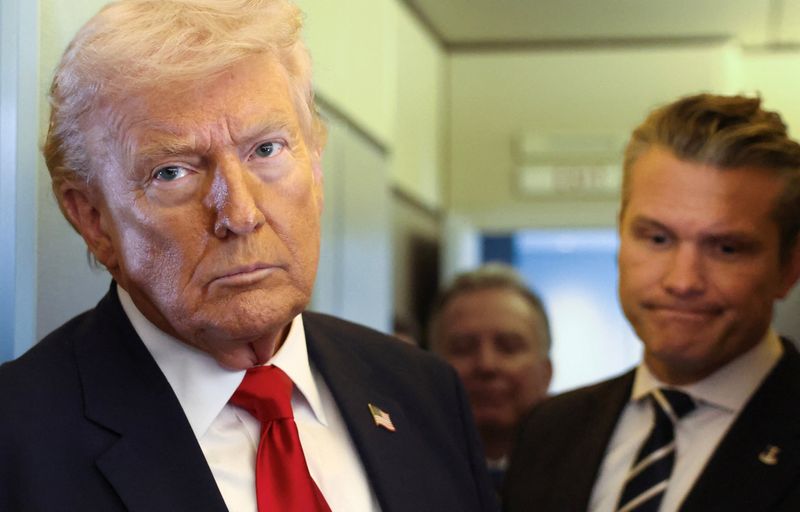 U.S. President Donald Trump, with Secretary of Defense Pete Hegseth at his side, looks on as he speaks to reporters aboard Air Force One on a flight from Dover, Delaware, to Miami, Florida, U.S., March 7, 2026. REUTERS/Kevin Lamarque