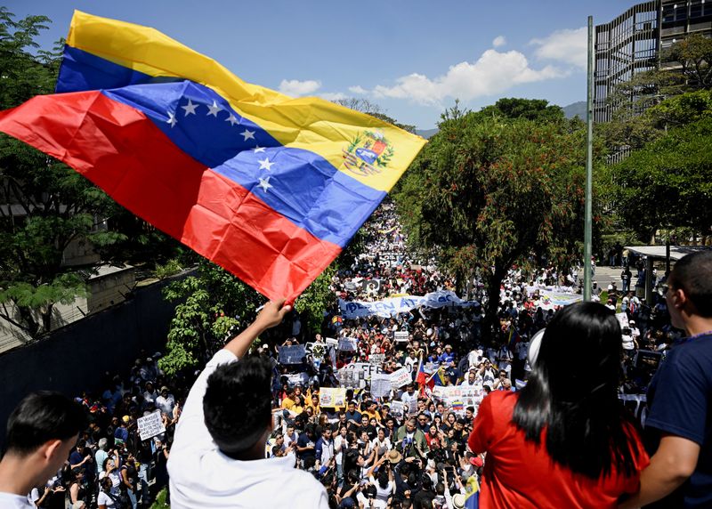 FILE PHOTO: A man waves a Venezuelan flag as university students and relatives of detainees mark Youth Day with a march calling for amnesty for political prisoners, highlighting continued demands for political reforms in the country, in Caracas, Venezuela, February 12, 2026. REUTERS/Maxwell Briceno/ File Photo