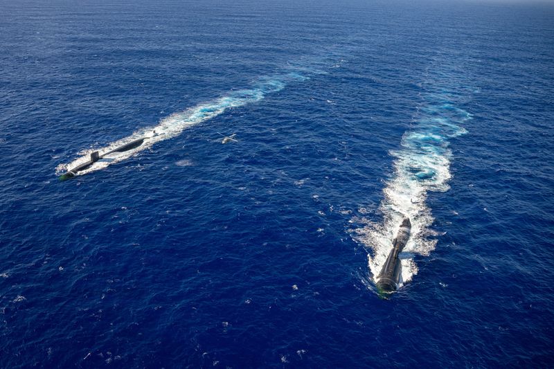 Los Angeles-class fast-attack submarines USS Annapolis (SSN 760) and USS Asheville (SSN 758) in formation with an MH-60S Sea Hawk attached to the "Island Knights" of Helicopter Sea Combat Squadron (HSC) 25 during a photo exercise off the coast of Guam, December 17, 2025. U.S. Navy/Lt. James Caliva/Handout via REUTERS/File Photo