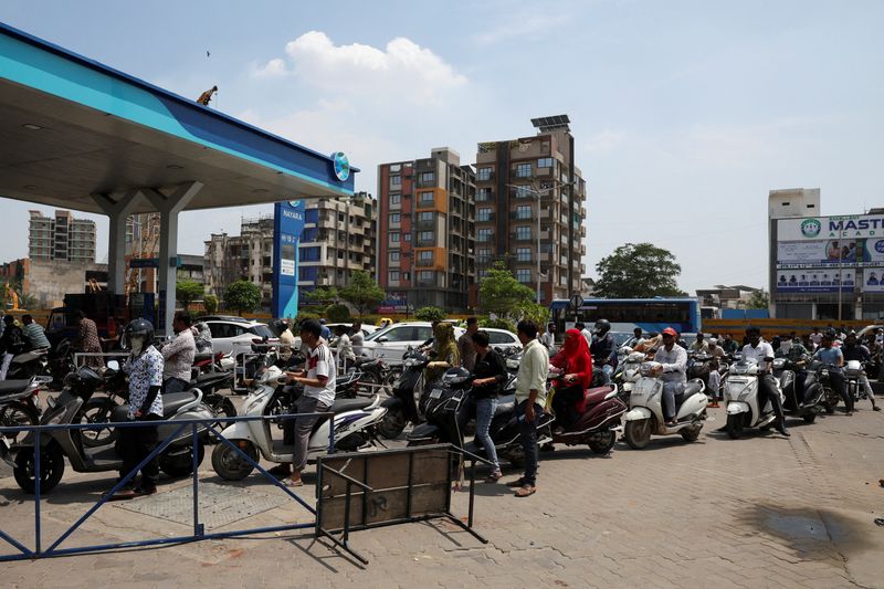 FILE PHOTO: People queue to fill petrol in their two-wheelers with concerns over potential supply disruptions, but authorities say there are no shortages, amid the ongoing U.S.-Israeli conflict with Iran, in Ahmedabad, India, March 24, 2026. REUTERS/Amit Dave/File Photo