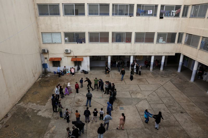 Children play at the yard of a school used as a temporary shelter for displaced people, following an escalation between Hezbollah and Israel, amid the U.S.-Israeli conflict with Iran, in Beirut, Lebanon, March 23, 2026. REUTERS/Mohamed Azakir
