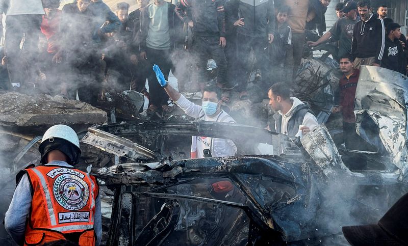 Emergency services work at the site of what medics said was an Israeli airstrike on a car near the entrance to Zawayda town, amid the U.S.-Israeli conflict with Iran, in the central Gaza Strip, April 4, 2026. Picture taken with a mobile phone.  REUTERS/Stringer