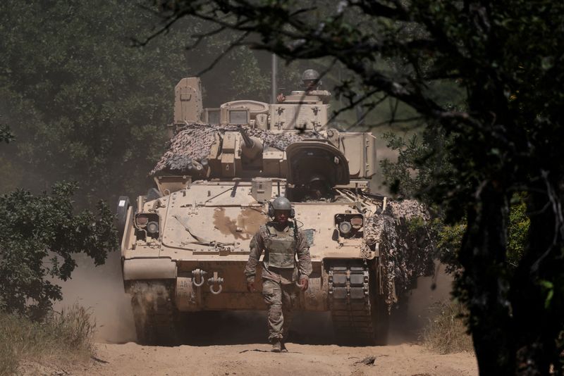 FILE PHOTO: A U.S. soldier walks in front of an armoured vehicle during "Balkan Sentinel - 25" military drill, an exercise involving personnel and equipment from the Bulgarian Land Forces and Air Force, formations from the NATO Multinational Battle Group with Italy, and a mechanized platoon from the Romanian Land Forces, in Koren, Bulgaria, June 9, 2025. REUTERS/Stoyan Nenov/File Photo