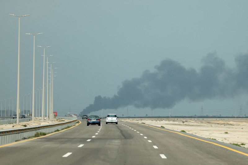 FILE PHOTO: Vehicles move along a road as smoke billows from Saudi Aramco's Ras Tanura oil refinery after a reported Iranian drone strike, amid the U.S.-Israel conflict with Iran, in Ras Tanura, Saudi Arabia, March 2, 2026. REUTERS/Stringer/File Photo