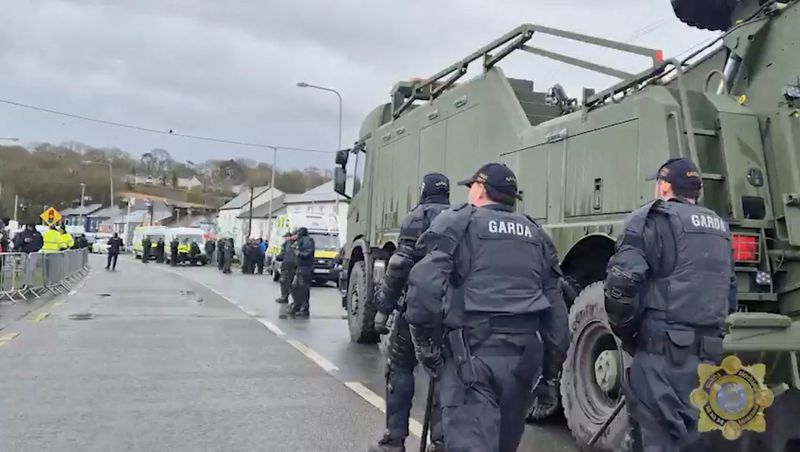Irish Garda Siochana (police) officers walk during an operation to clear protesters blockading the Whitegate oil refinery, in Whitegate, County Cork, Ireland, April 11, 2026, in this screengrab from a video. An Garda Siochana/Handout via REUTERS