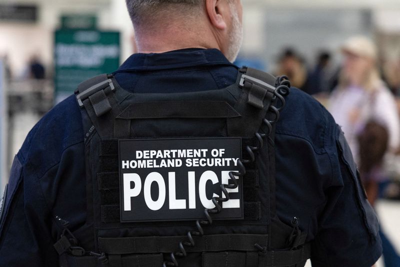 FILE PHOTO: A Department of Homeland Security officer directs passengers as they wait in long TSA lines at the George Bush Intercontinental Airport in Houston, Texas, U.S., March 25, 2026.    REUTERS/Antranik Tavitian/File Photo
