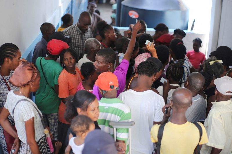 People gather to receive food at the temporary shelter in College des Antilles as the country faces emergency food insecurity while immersed in a social and political crisis, in Port-au-Prince, Haiti October 4, 2024. REUTERS/Jean Feguens Regala