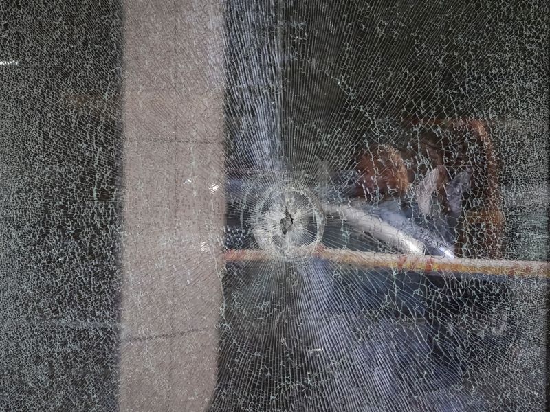 Residents reflected in the supermarket window with a bullet hole at the site of yesterday's shooting incident, in Kyiv, Ukraine, April 19, 2026. REUTERS/Gleb Garanich