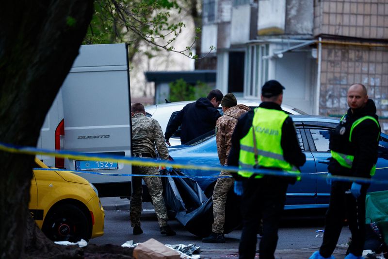 A victim in a bodybag is carried, at the site of a shooting incident, in Kyiv, Ukraine, April 18, 2026. REUTERS/Valentyn Ogirenko
