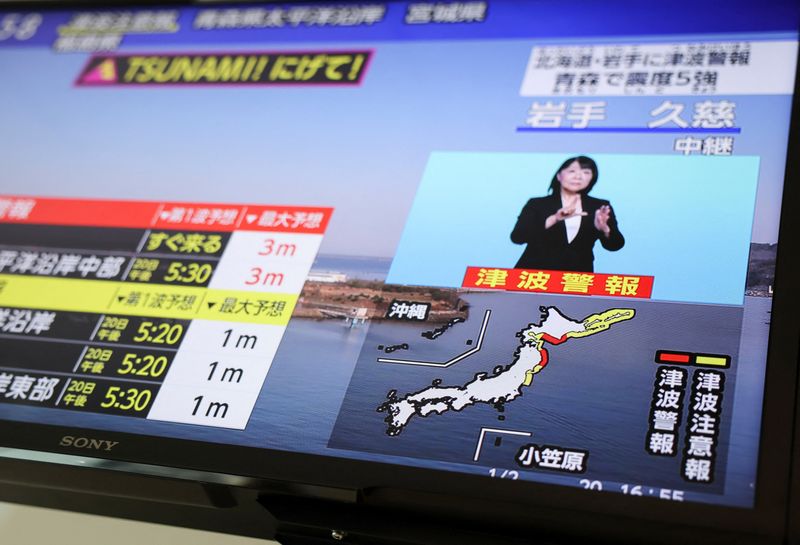 A television screen shows a news report on Japan Meteorological Agency's tsunami warning, saying it expected tsunami waves of up to 3 meters (9.84 feet) to reach large coastal areas in northern Japan after an earthquake with a preliminary magnitude of 7.4 struck off the northeastern coast of Japan, in Tokyo, Japan April 20, 2026.REUTERS/Issei Kato