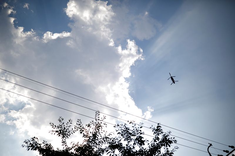 FILE PHOTO: A military helicopter carrying a container flies toward a golf course where a Terminal High Altitude Area Defense (THAAD) system is deployed, in Seongju, South Korea, June 14, 2017.  REUTERS/Kim Hong-Ji/File Photo