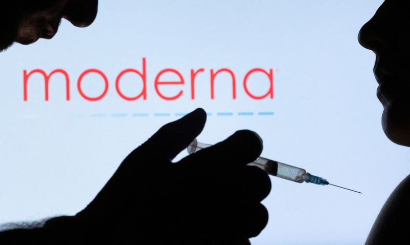 FILE PHOTO: People pose with syringe with needle in front of displayed Moderna logo in this illustration taken, December 11, 2021. REUTERS/Dado Ruvic/Illustration/File Photo