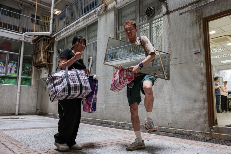 Dorz Cheung, a resident of Wang Fuk Court, holds family belongings, which he retrieved from his flat during his first return visit home since a deadly fire last year, in Hong Kong, China, April 21, 2026. REUTERS/Tyrone Siu
