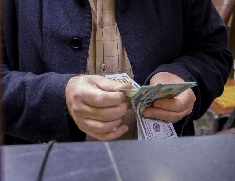 FILE PHOTO: A man counts U.S. dollars at a currency exchange shop in Baghdad, Iraq, January 23, 2023. REUTERS/Ahmed Saad/ File Photo